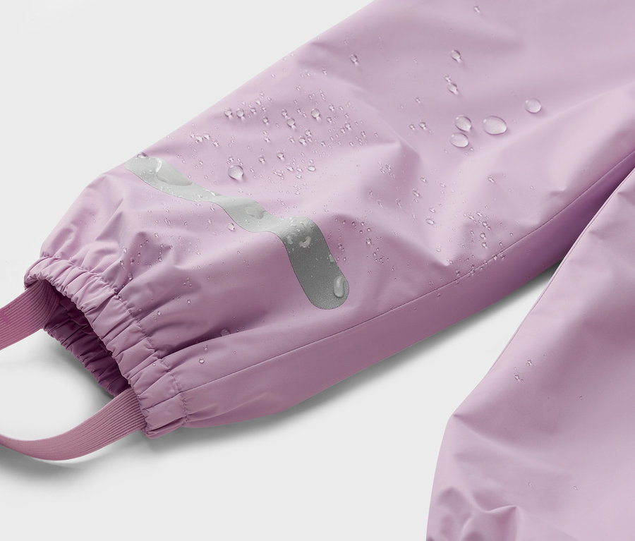 Gros plan sur l'extrémité de la manche d'un pantalon imperméable lilas avec un élastique, une bande réfléchissante et un élastique.