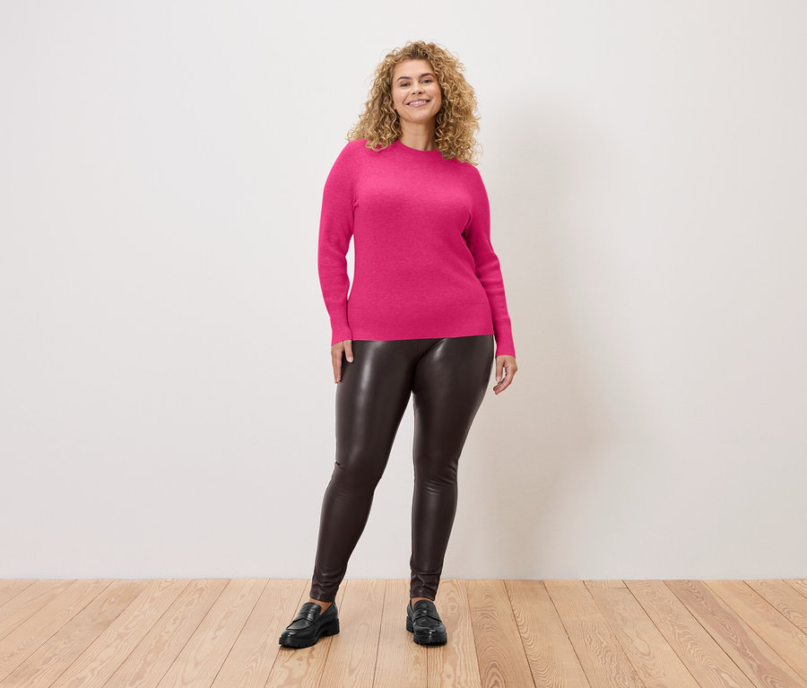 Femme portant un legging aspect cuir et un pull en maille fine fuchsia.