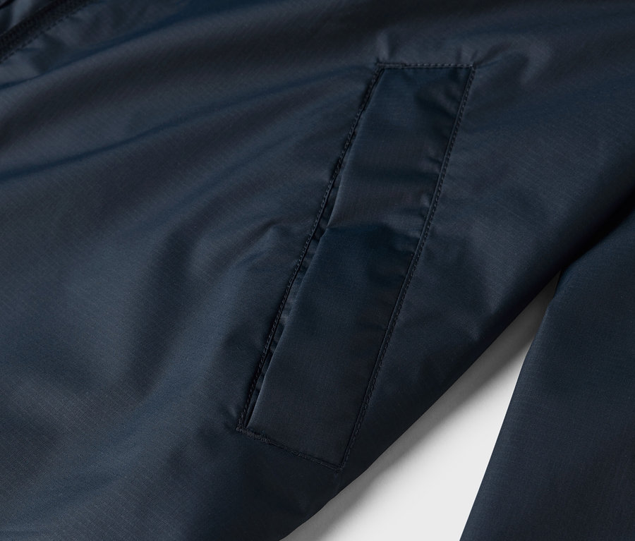 Gros plan sur une veste bleu marine avec une poche plaquée.