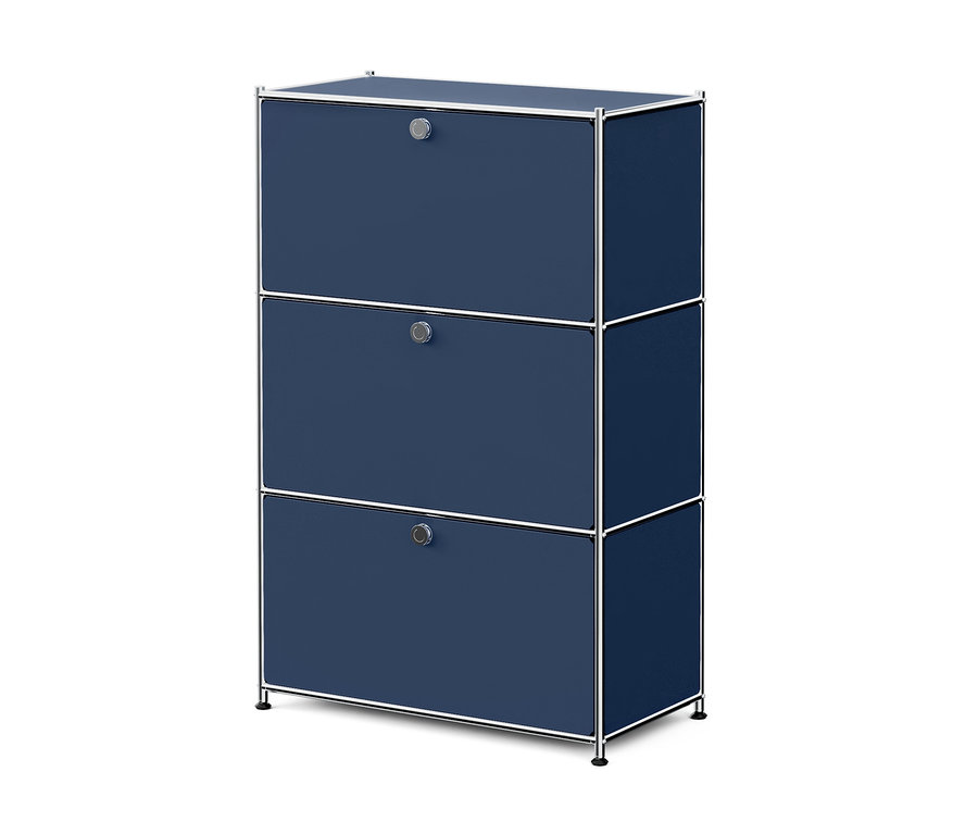Armoire bleu foncé avec trois compartiments superposés, chacun avec une poignée ronde argentée et un cadre chromé, reposant sur de courts pieds.