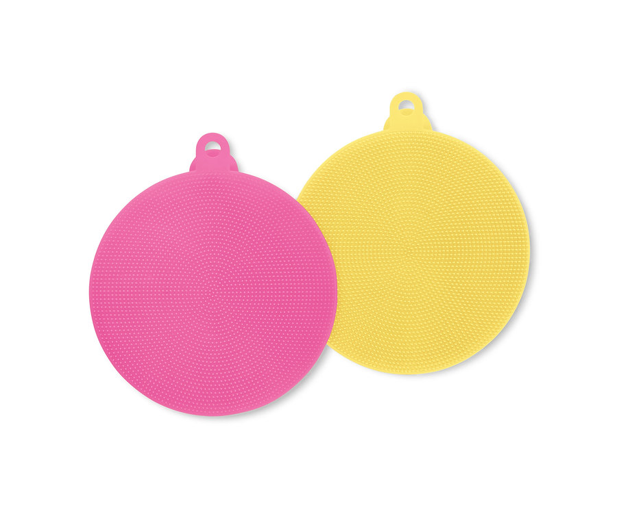 Un tampon exfoliant rond en silicone rose et un jaune sont superposés.