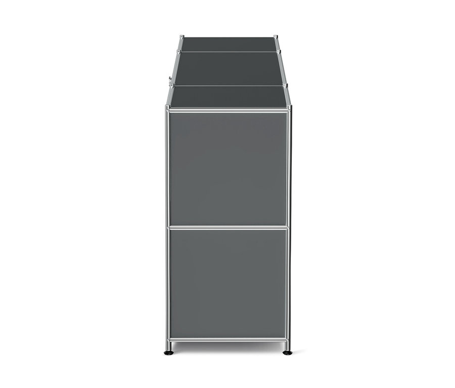Meuble de rangement modulaire haut et étroit, gris foncé, avec un cadre argenté, montrant deux compartiments superposés sur le côté et une surface supérieure divisée, reposant sur de petits pieds noirs.