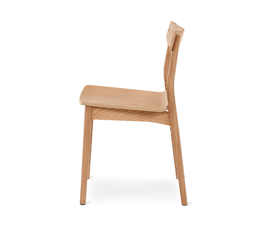 Chaise en bois clair vue de côté, avec un dossier et une assise incurvés, sur fond blanc.