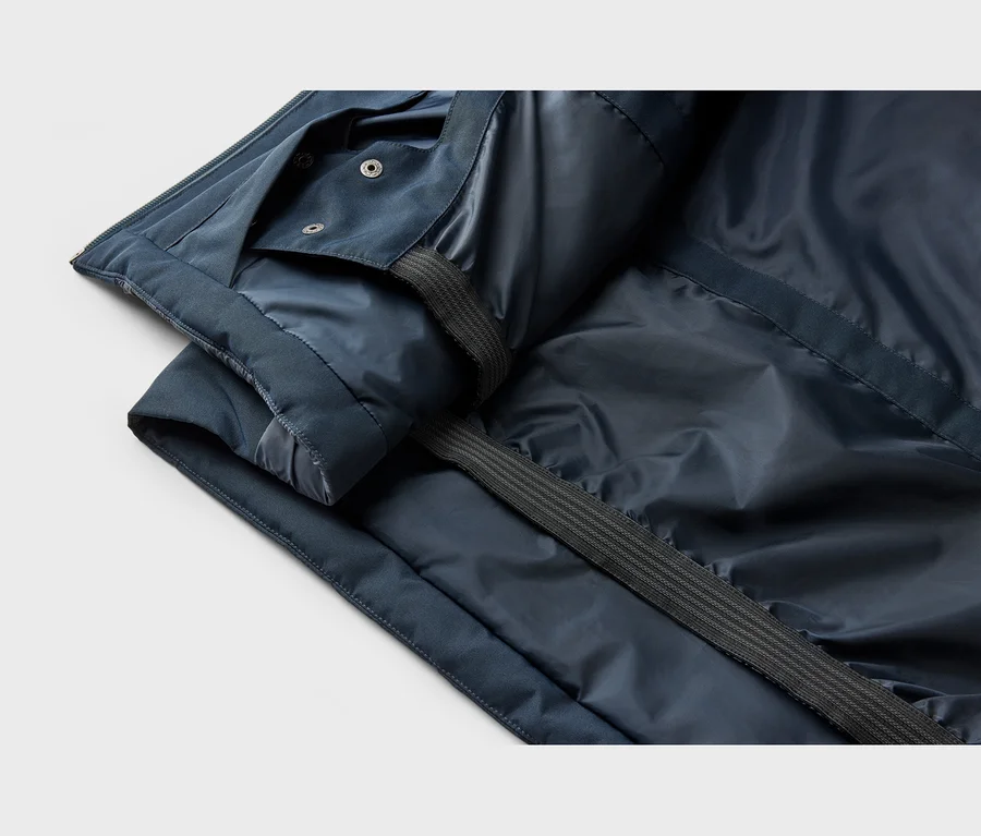 Gros plan de l'intérieur d'une veste bleu foncé avec une doublure brillante, des boutons-pression et une sangle côtelée.
