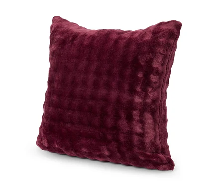 Coussin carré bordeaux avec une housse douce posé sur une surface blanche.