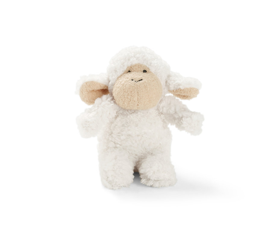 Un petit mouton sonore en peluche se dresse sur un fond blanc.