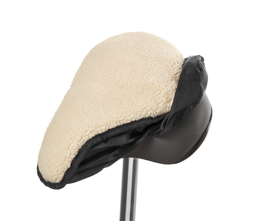 Gros plan d'une housse de selle 2 en 1 avec peau d'agneau beige et bordure en nylon noir.