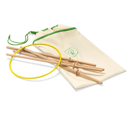 Un anneau volant jaune, des bâtons en bois et un sac en tissu crème avec une bordure verte.