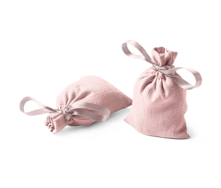 Deux sachets parfumés, un couché, un debout, tous deux roses avec un ruban.