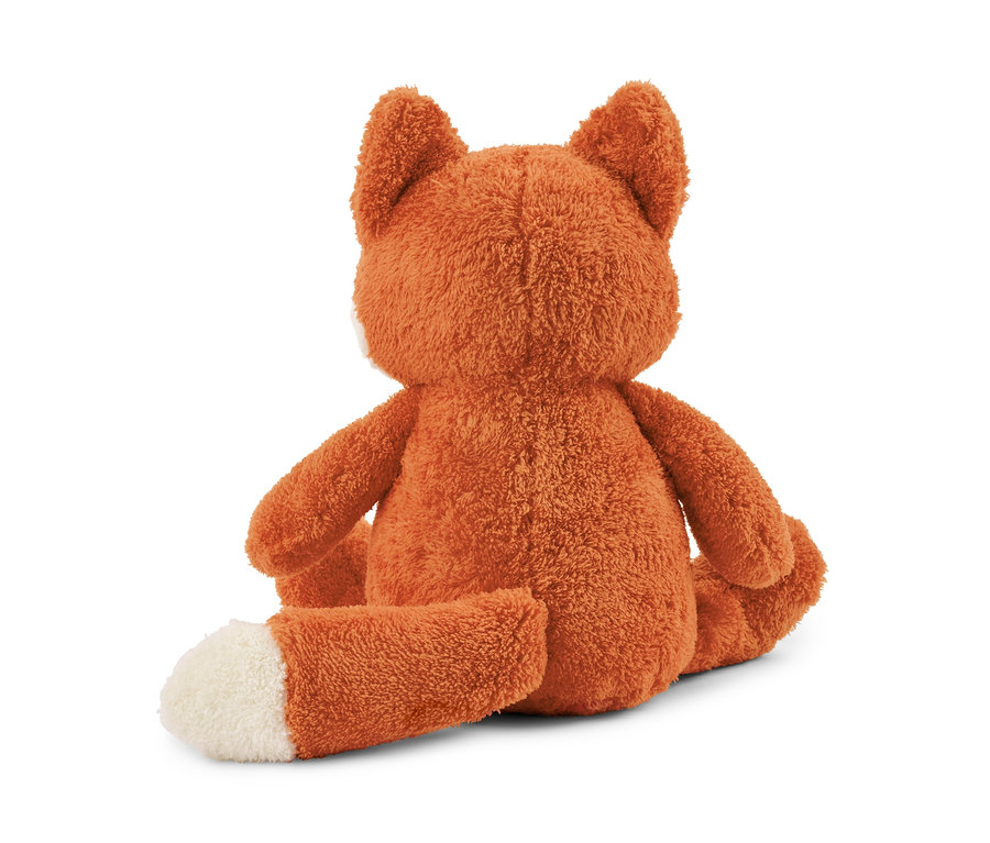 Une peluche « renard » marron est assise, le dos tourné à la caméra, et a le bout de la queue blanc.