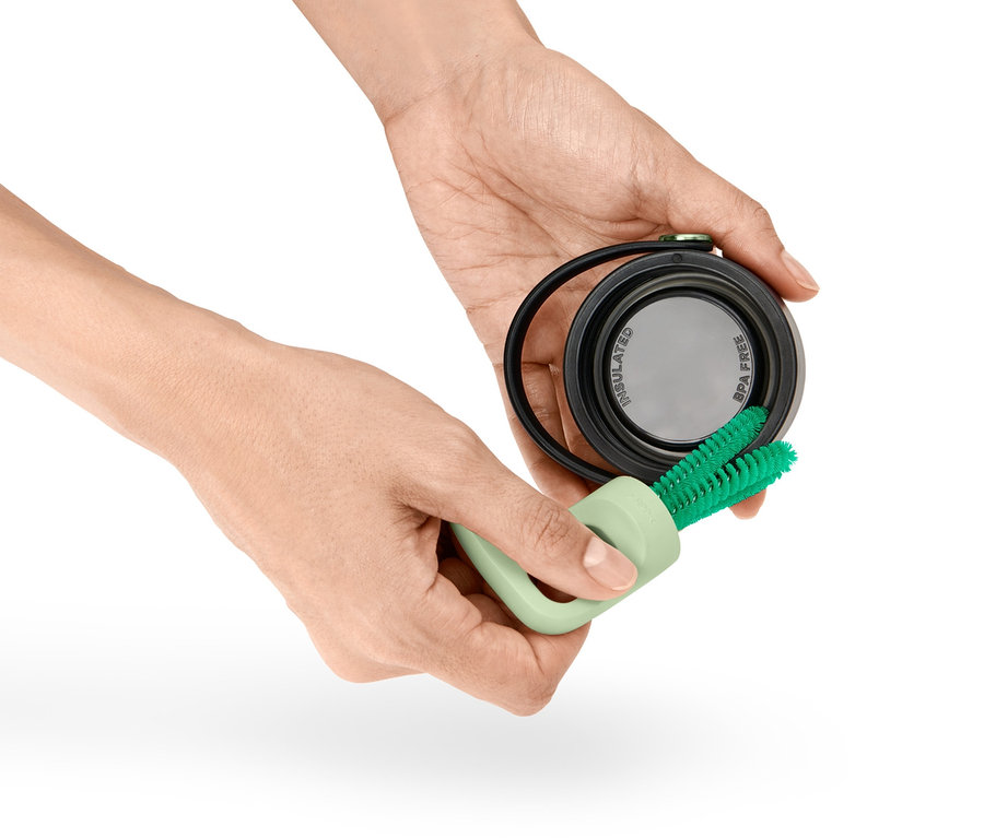 Les mains tiennent une brosse à vaisselle pour verres et bouteilles 3 en 1 et nettoient un couvercle.