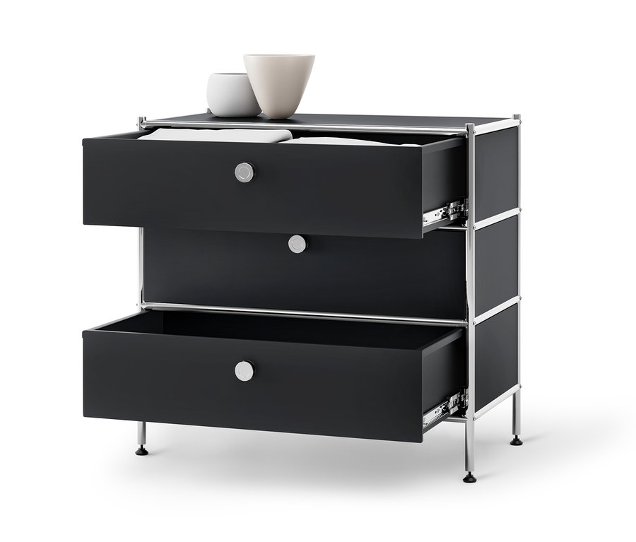 Commode en métal noire « CN3 » avec 3 tiroirs dont deux ouverts et deux vases sur le dessus.