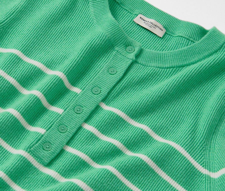 Vue détaillée d'un pull en maille fine rayé vert et blanc avec une patte de boutonnage.