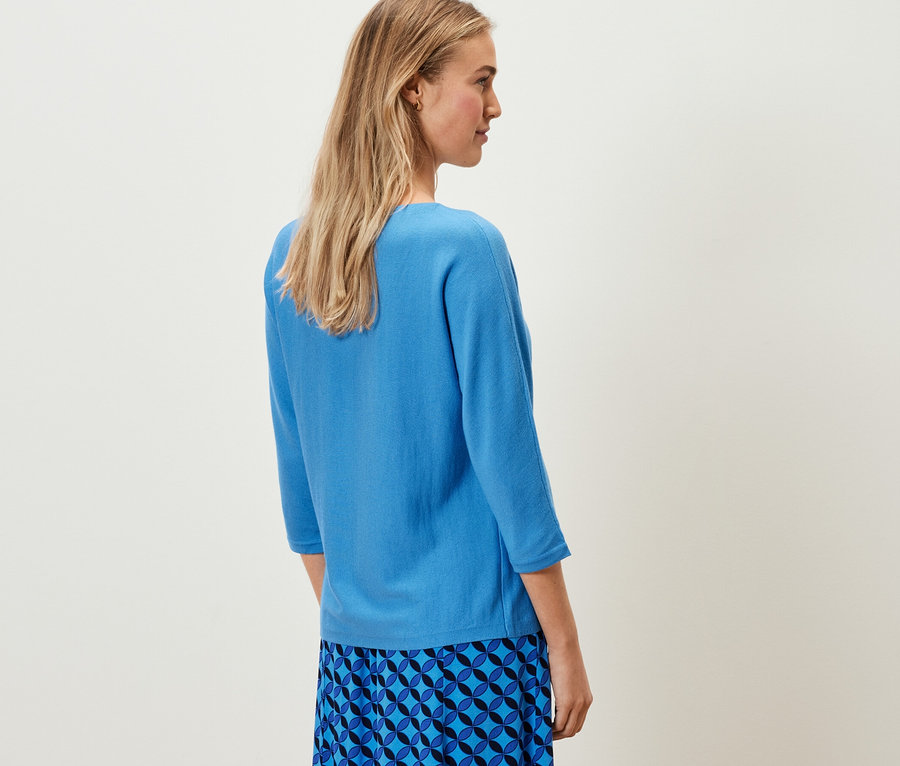 Femme portant un pull en maille fine mérinos bleu cobalt.