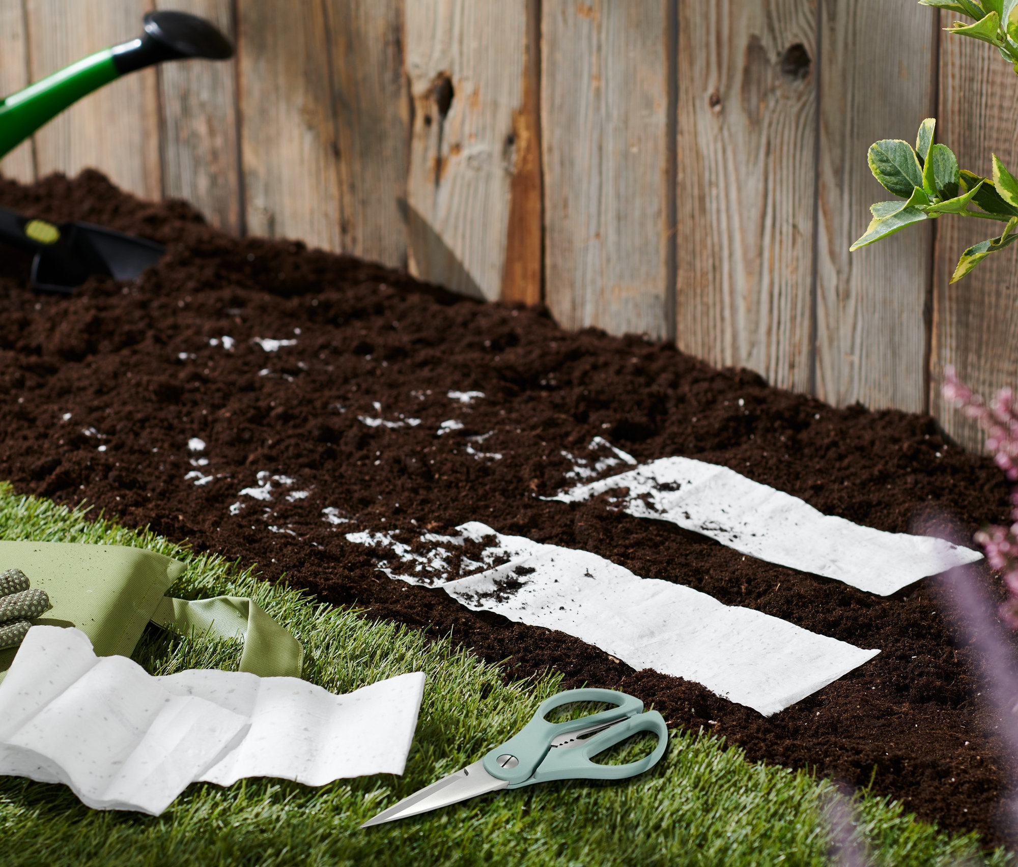 Outils de jardinage et tapis de semences Prairie pour abeilles sur une pelouse à côté de la terre.