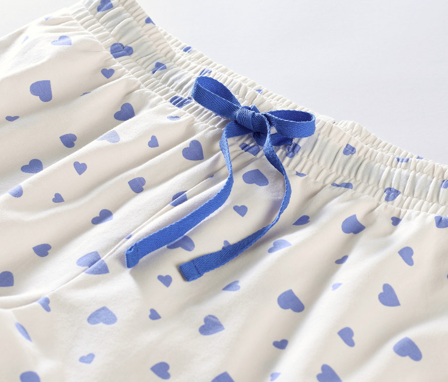 Détail d'un pyjashort à cœurs avec un ruban bleu.