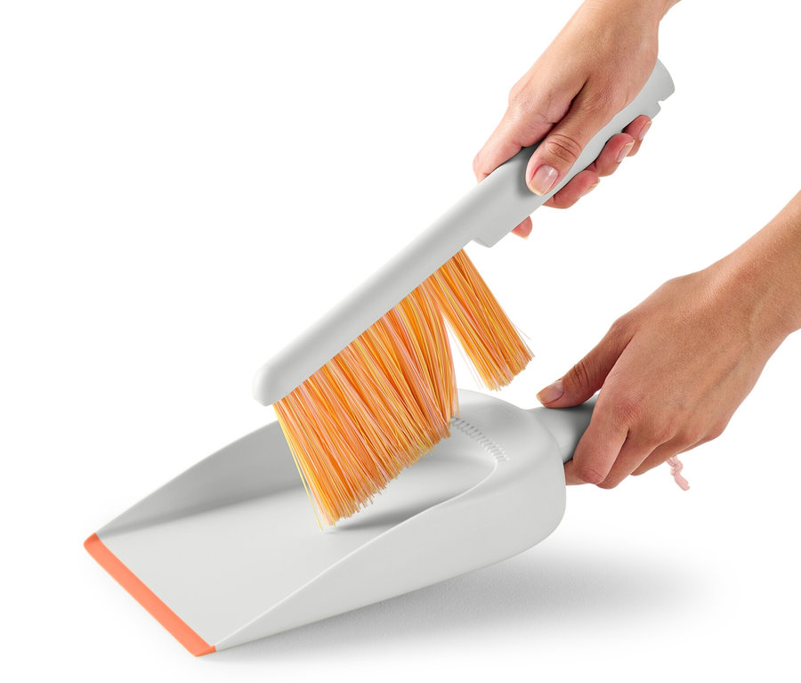 Une femme utilise une pelle et une balayette.