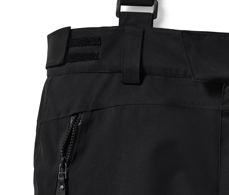 Gros plan sur un pantalon de ski high-tech noir avec fermeture éclair et bretelles.