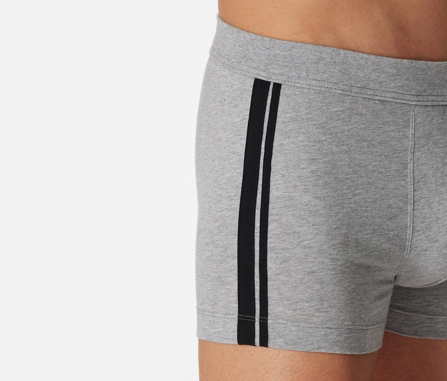 Gros plan sur un short SCHIESSER gris chiné avec des rayures noires sur le côté.