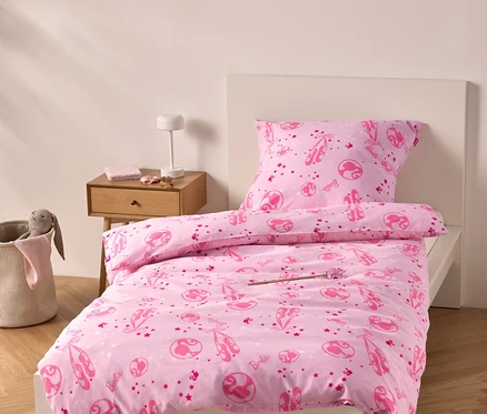Linge de lit rose avec des motifs de ballerines sur un lit.