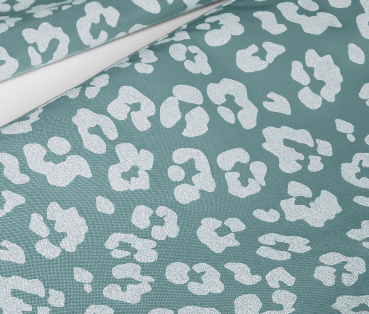 Gros plan sur un pantalon de pluie pour enfant avec des éléments réfléchissants et un imprimé animalier.