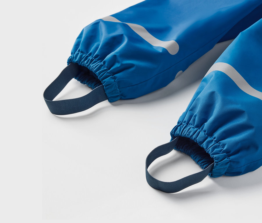 Gros plan sur un pantalon de pluie thermique bleu pour enfant.