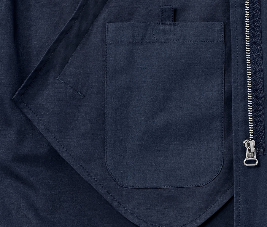 Détail d'une parka bleue avec poche et fermeture éclair.