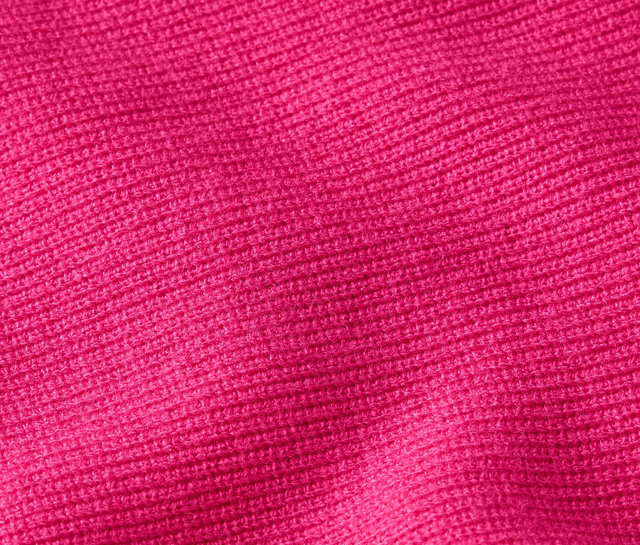 Gros plan sur la texture d'un tricot en rose vif.