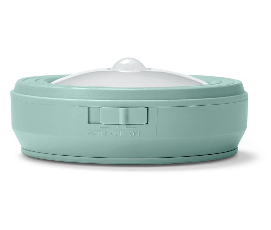 Détail d'une veilleuse ronde vert menthe avec diffuseur blanc et interrupteur.