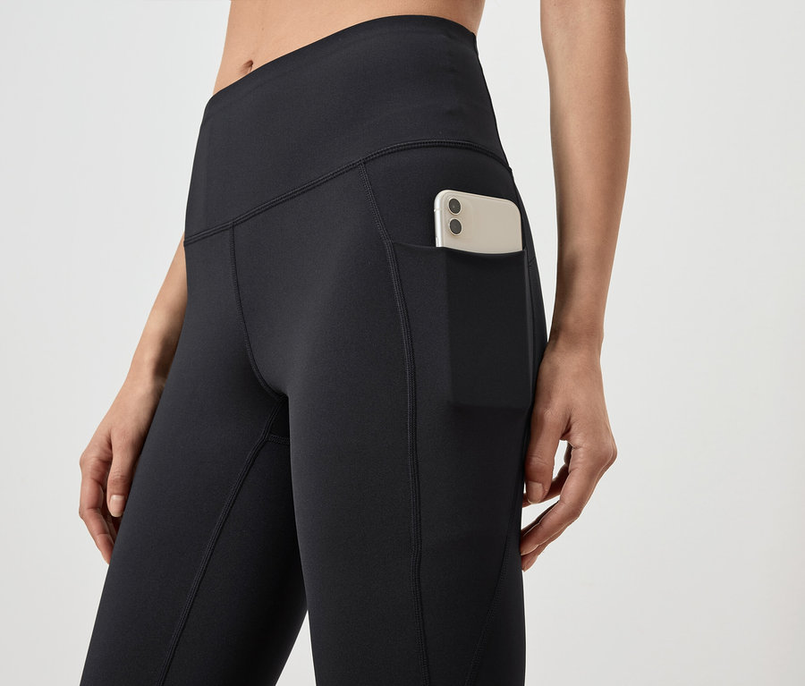Détail de leggings noirs pour femmes avec poche et téléphone portable.