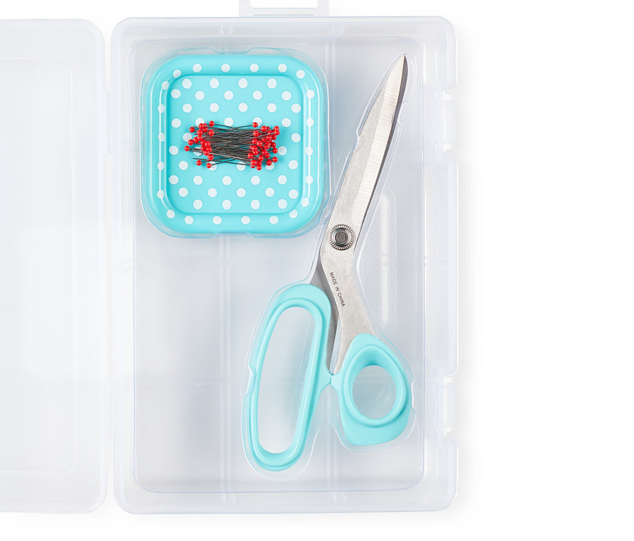 Ciseaux et coussin à épingles avec des épingles rouges dans une boîte en plastique transparente. Prym Starter-Set Nähen »Love«.
