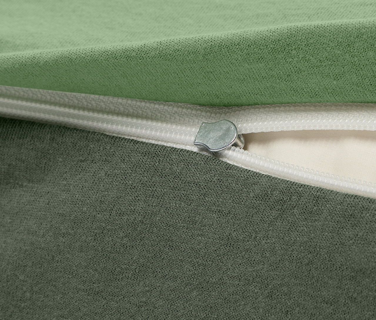 Gros plan d'une housse en tissu vert et gris avec fermeture éclair.