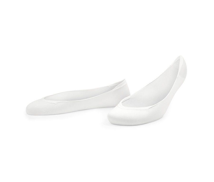 Deux paires de socquettes invisibles blanches pour ballerines sont posées sur le sol.
