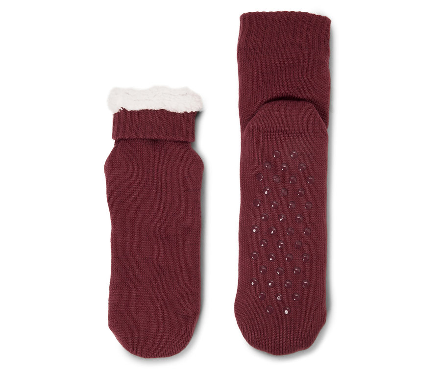 Deux chaussettes bordeaux. L'une a un bord en peluche blanche et l'autre des points antidérapants.