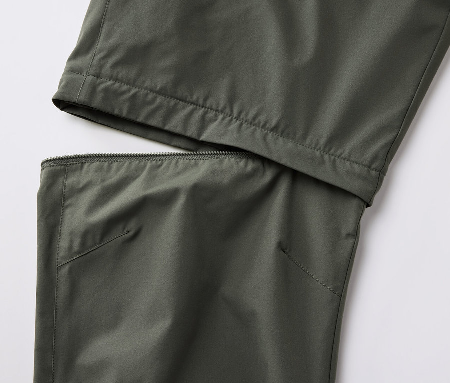 Gros plan d'un pantalon technique 2 en 1 kaki avec une fermeture éclair.