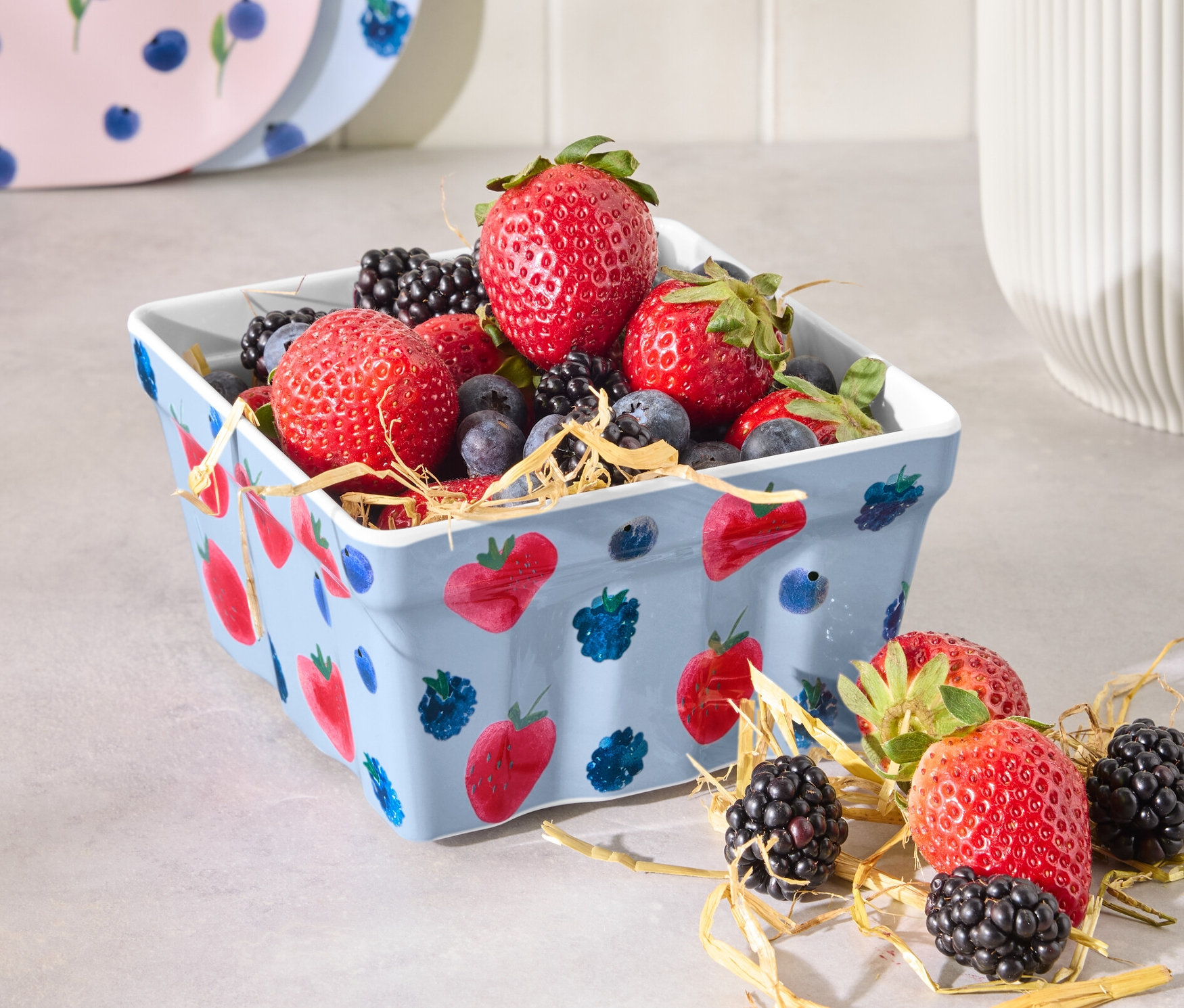 Un bac à fraises rempli de fraises, myrtilles et mûres.