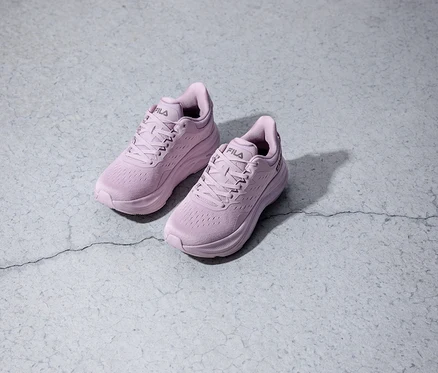 Deux chaussures de course Fila violettes posées sur un fond gris.