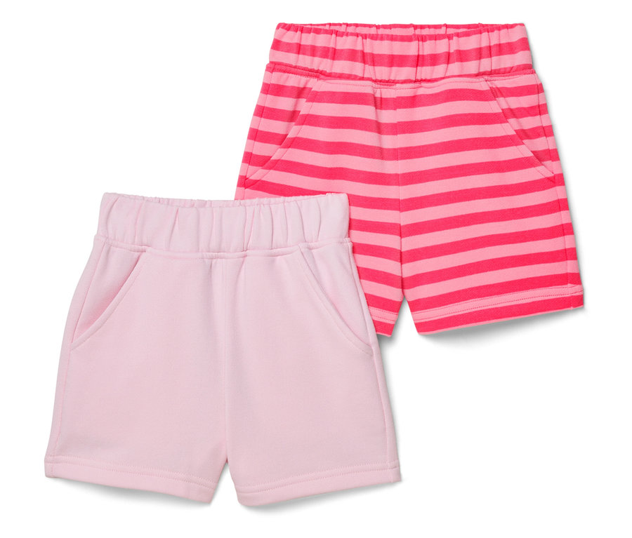 Deux shorts sont posés sur un fond blanc, un rose et un rose à rayures.