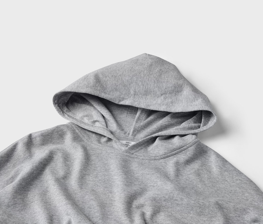 Gros plan d'un sweat à capuche gris posé sur un fond neutre.