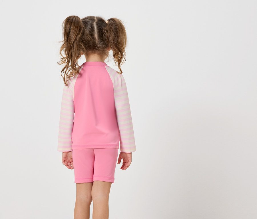 Vue arrière d'une petite fille avec des couettes portant un ensemble de maillot de bain deux pièces rose.