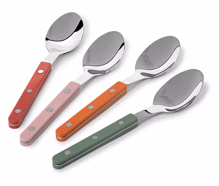 Quatre cuillères avec des manches rouges, roses, orange et verts sont disposées en diagonale sur un fond blanc.