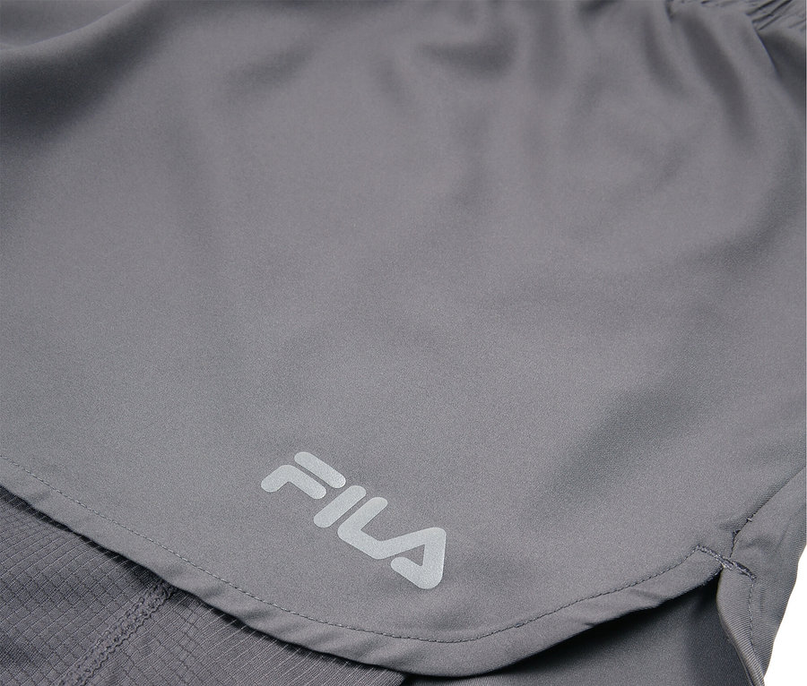 Gros plan d'un short Fila gris avec le logo Fila visible.
