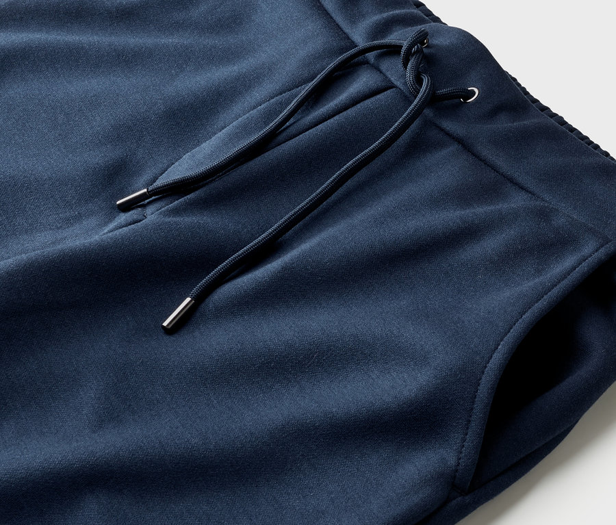 Gros plan d'un pantalon de survêtement bleu marine avec cordon de serrage et une poche.