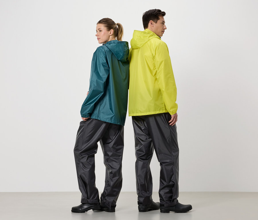 Une femme portant un imperméable turquoise et un homme portant un imperméable jaune se tiennent dos à dos sur un fond blanc.