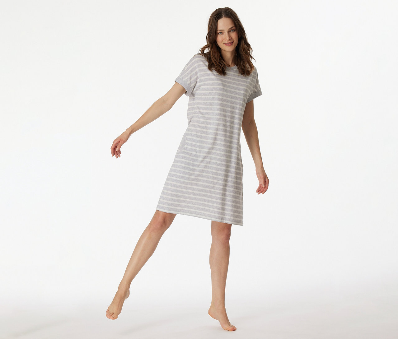 Femme en chemise de nuit SCHIESSER à manches courtes rayée levant une jambe.
