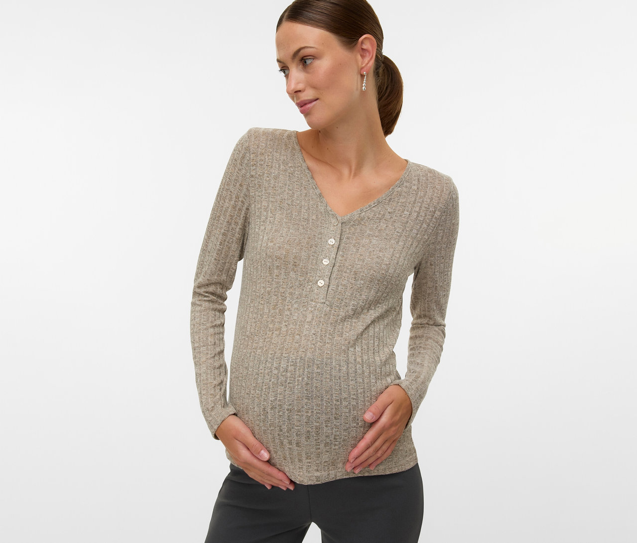 Femme enceinte portant un t-shirt MAMALICIOUS « MLPAMMIE LIA » à manches longues et boutons, tenant son ventre.