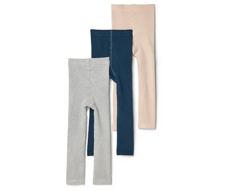 Trois leggings pour enfants en gris, bleu marine et beige sont superposés sur un fond blanc.
