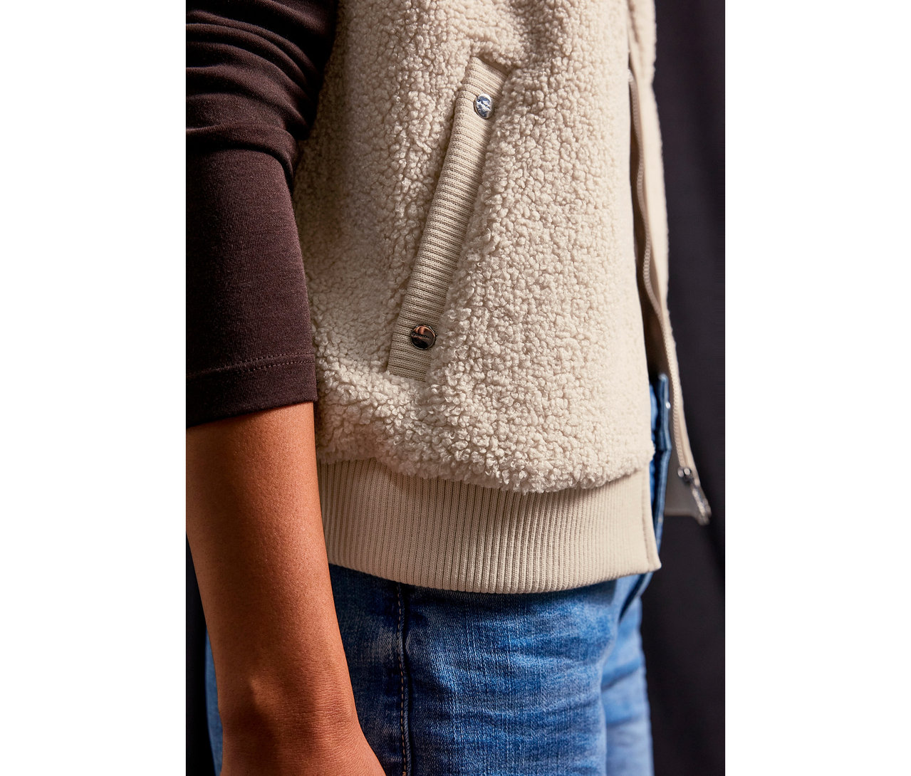 Gros plan d'une personne portant une veste en teddy Street One et un jean.