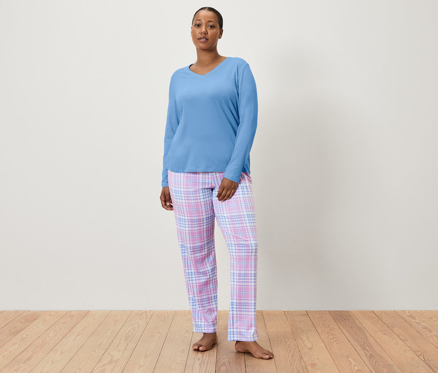 Femme portant un haut de pyjama bleu et un pantalon de pyjama à carreaux.