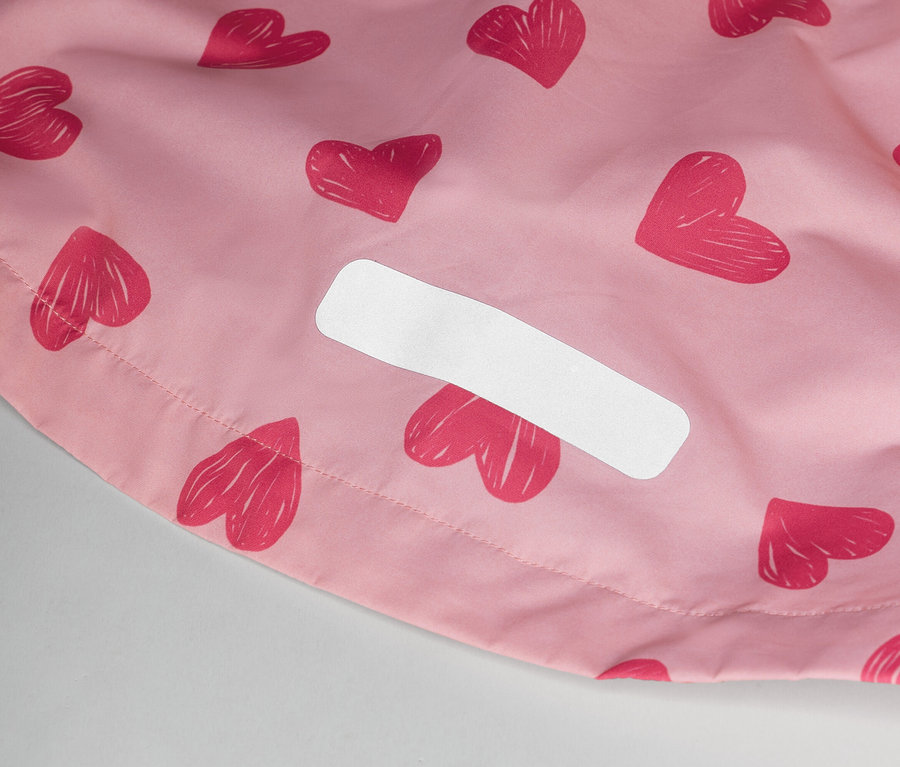 Gros plan d'un tissu rose à motif de cœurs avec une étiquette blanche.
